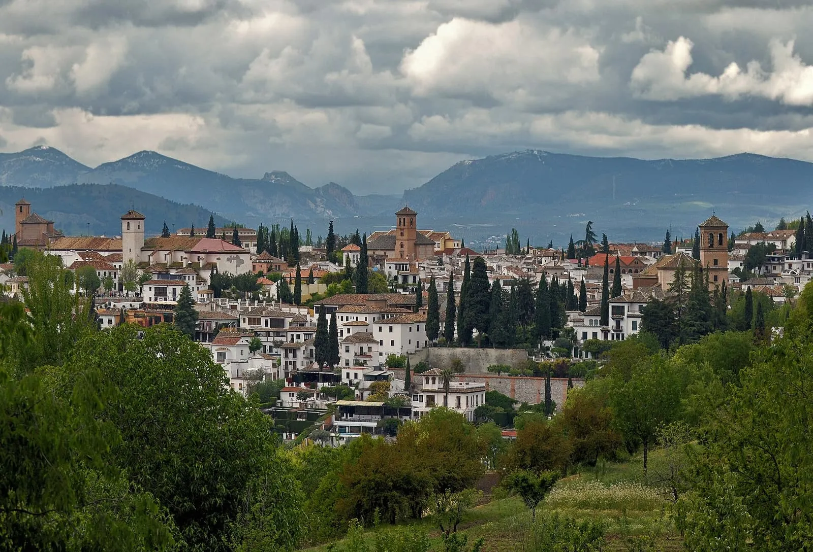 Les maisons blanches et les cyprès de l'Albaicín vus depuis l'Alhambra, sur fond de montagnes