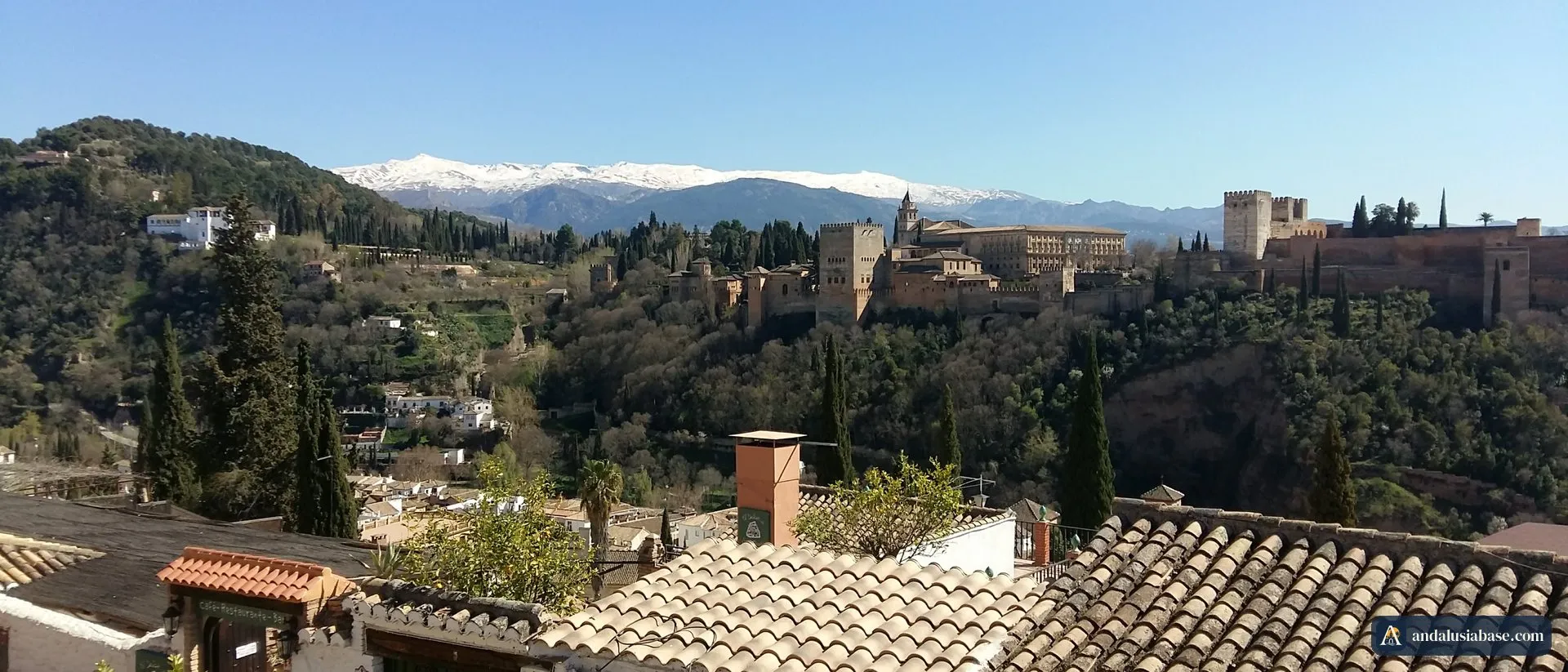 A Alhambra e a Serra Nevada coberta de neve vistas por cima dos telhados do Albaicín