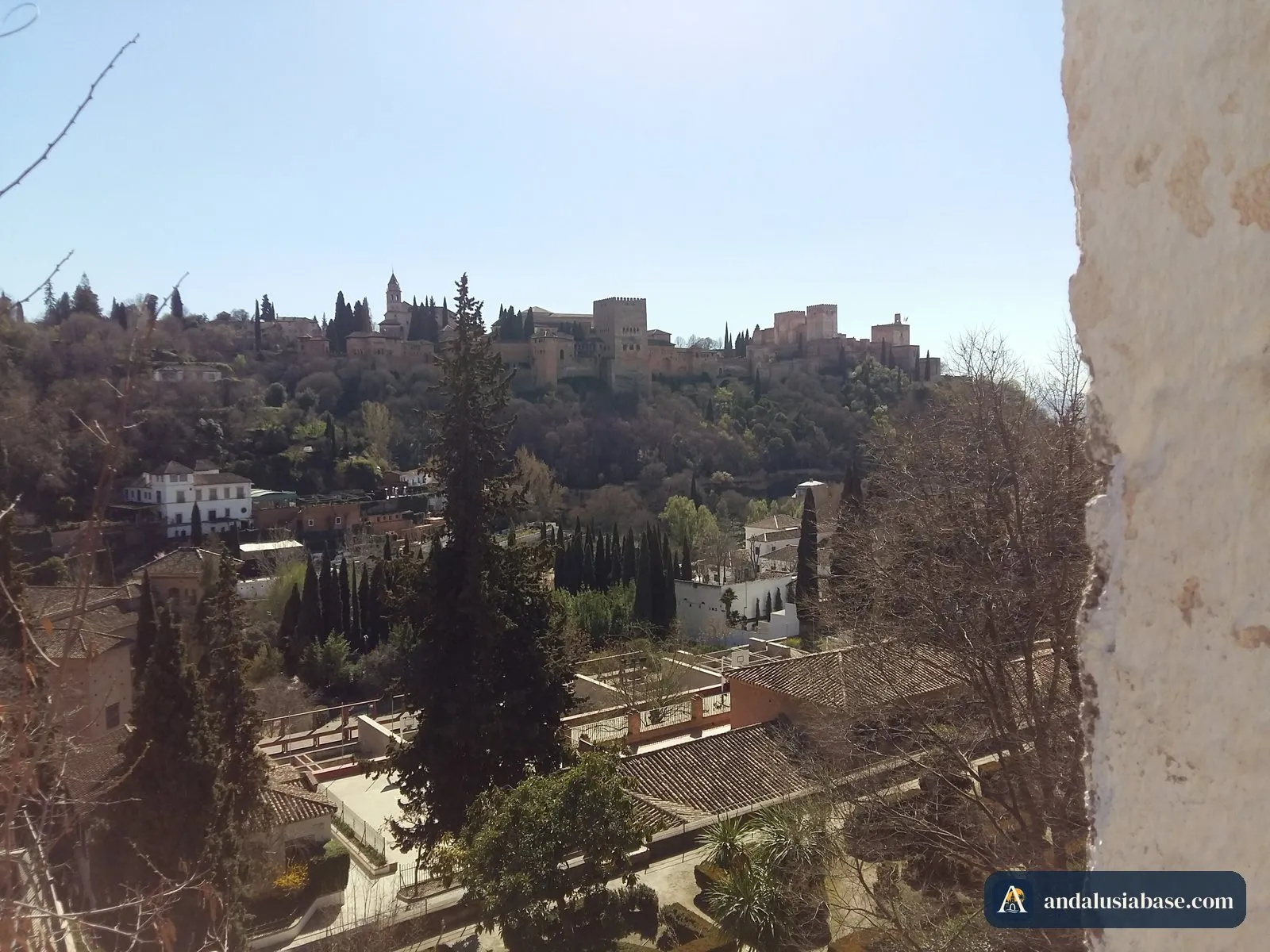 A Alhambra acima das árvores e telhados, vista de um miradouro do Albaicín