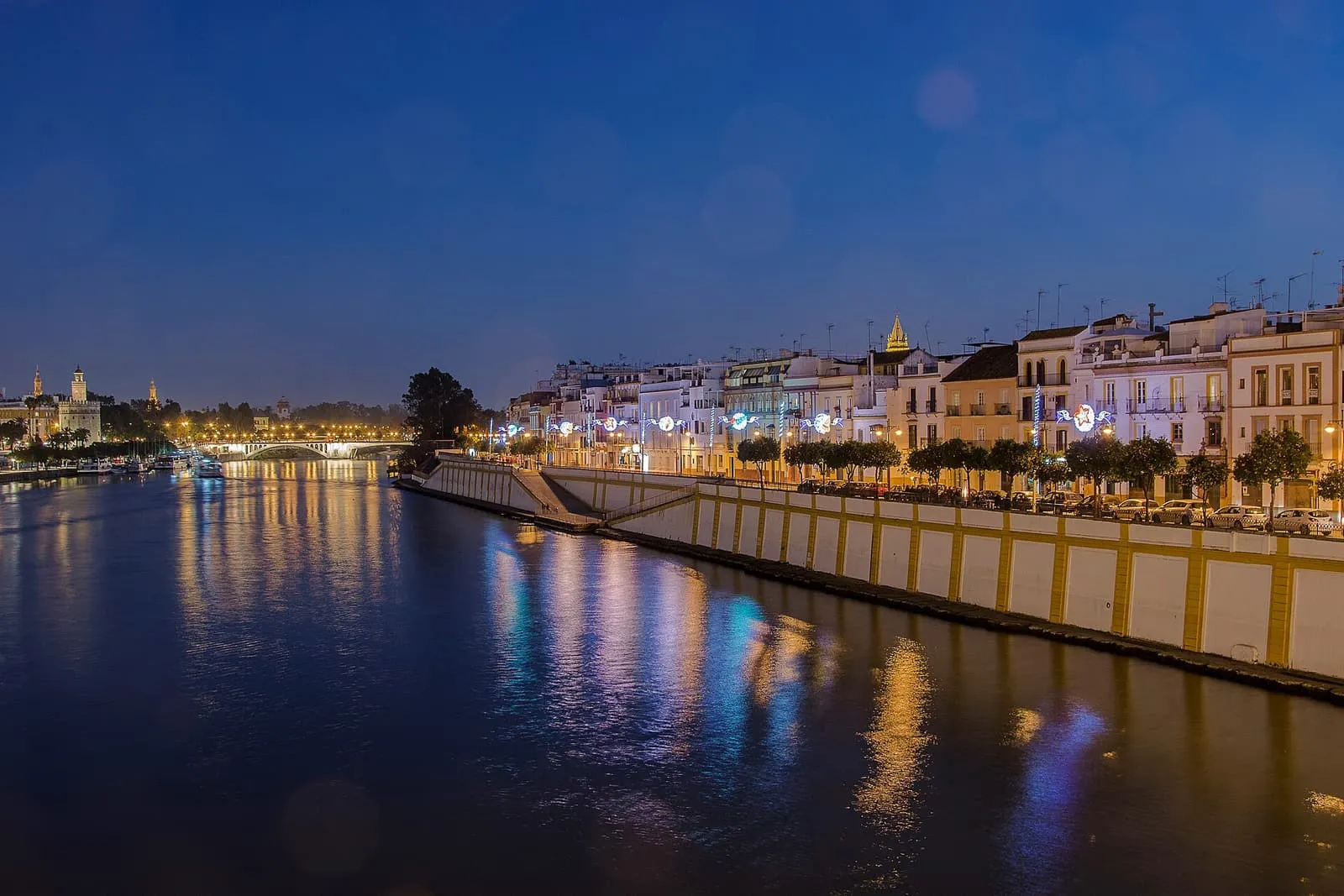 Le Guadalquivir à la nuit tombante et les maisons illuminées de la Calle Betis, à Triana, Séville