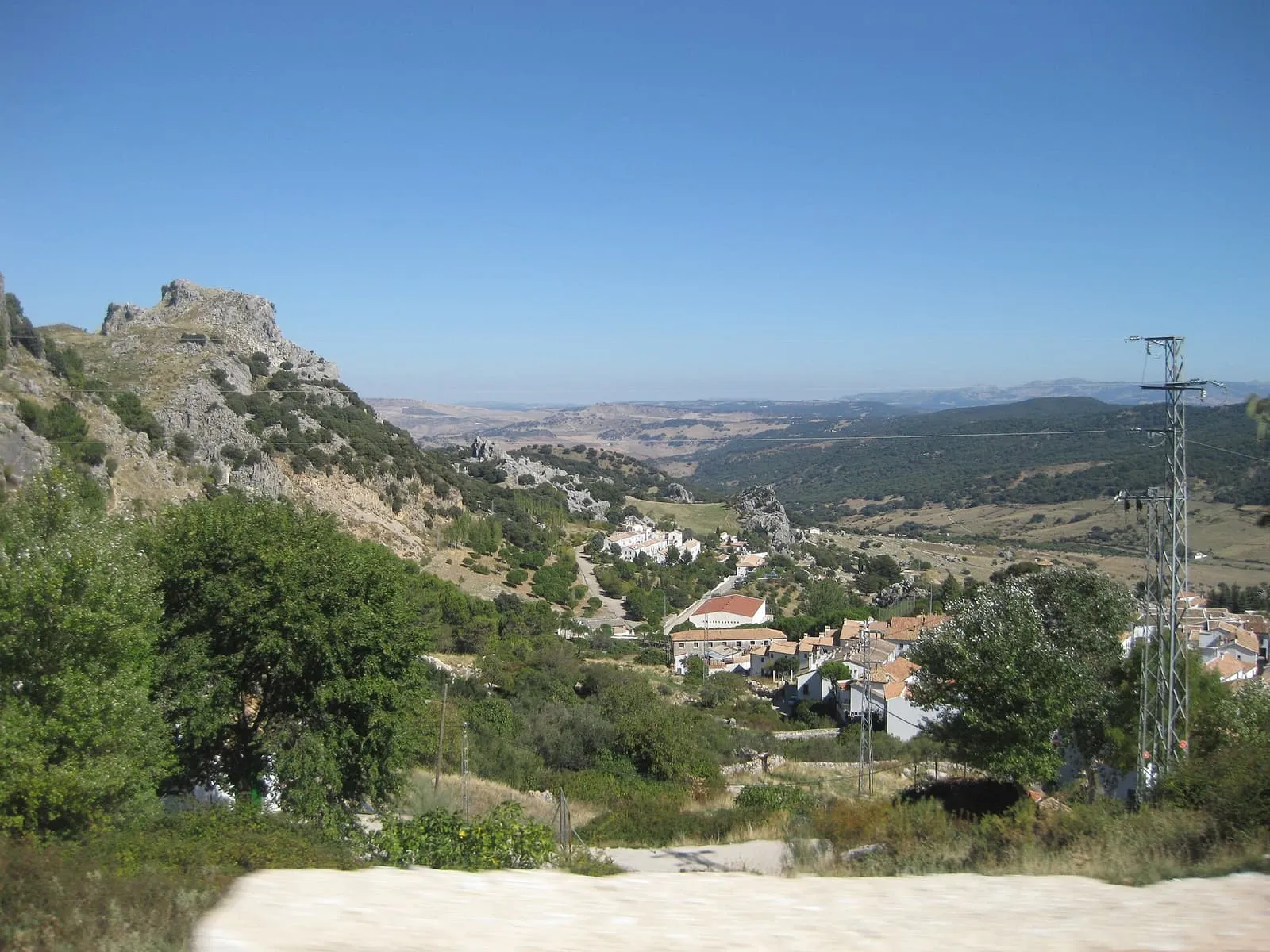 Collines verdoyantes et village blanc dans une vallée de la Sierra de Grazalema