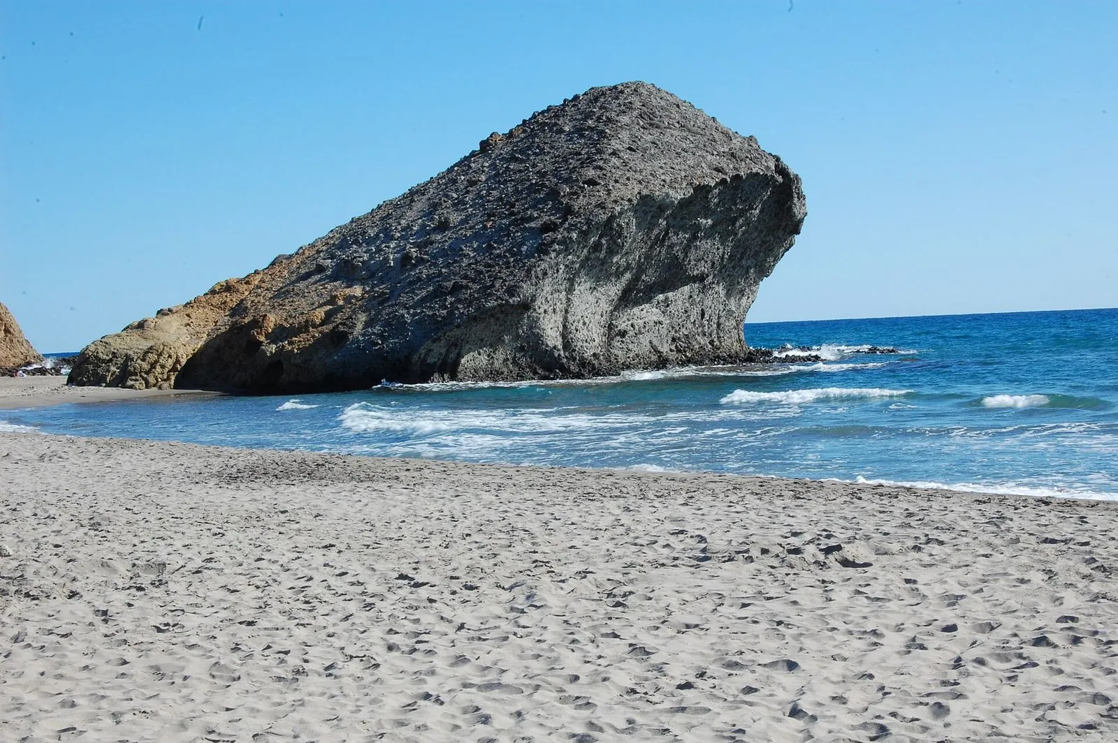 A praia de Mónsul, em Cabo de Gata, com a sua areia cinzenta e a rocha vulcânica conhecida como a Peineta