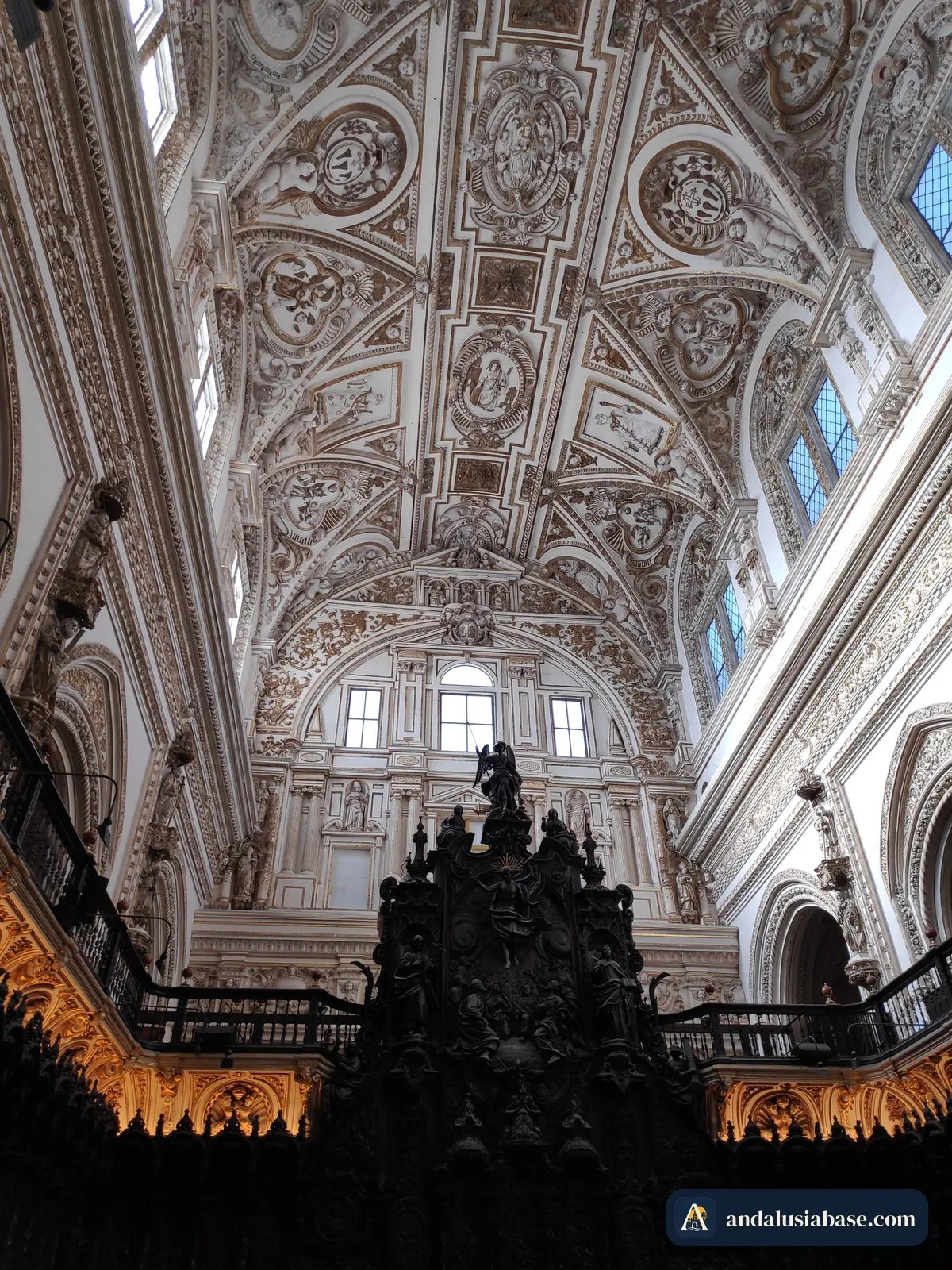 Cadeiral entalhado do coro sob o teto de estuque branco da catedral