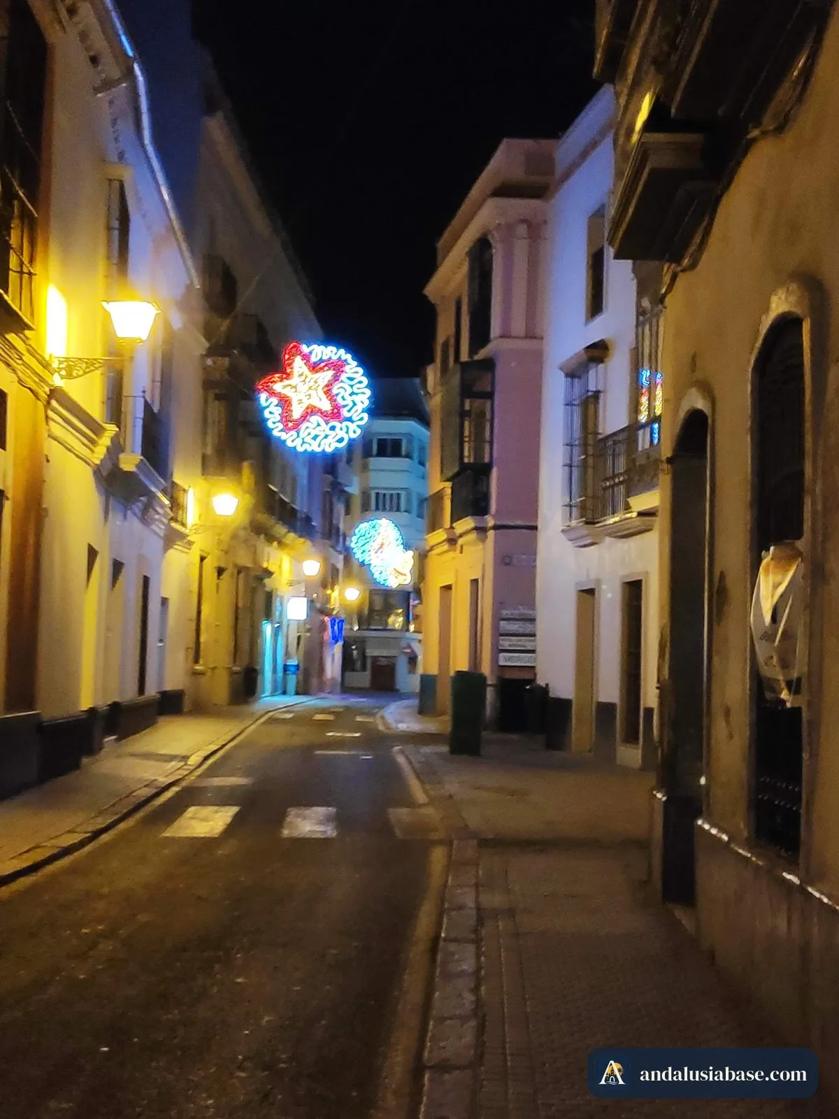 Uma rua tranquila do centro de Sevilha à noite, sob uma estrela de Natal iluminada