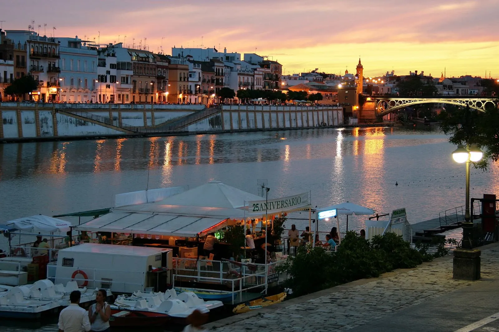 Le Guadalquivir au coucher du soleil, avec les maisons et le pont de Triana sur l'autre rive