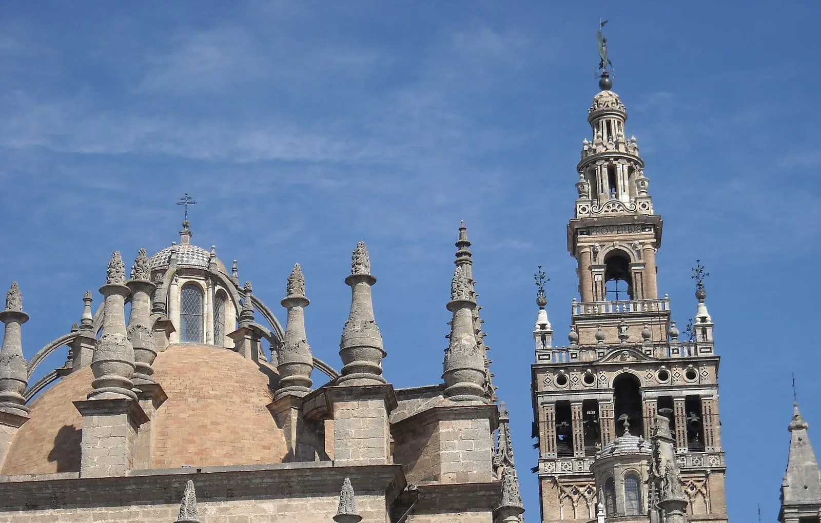 Der Glockenturm Giralda neben einer Kuppel und den Fialen der Kathedrale von Sevilla