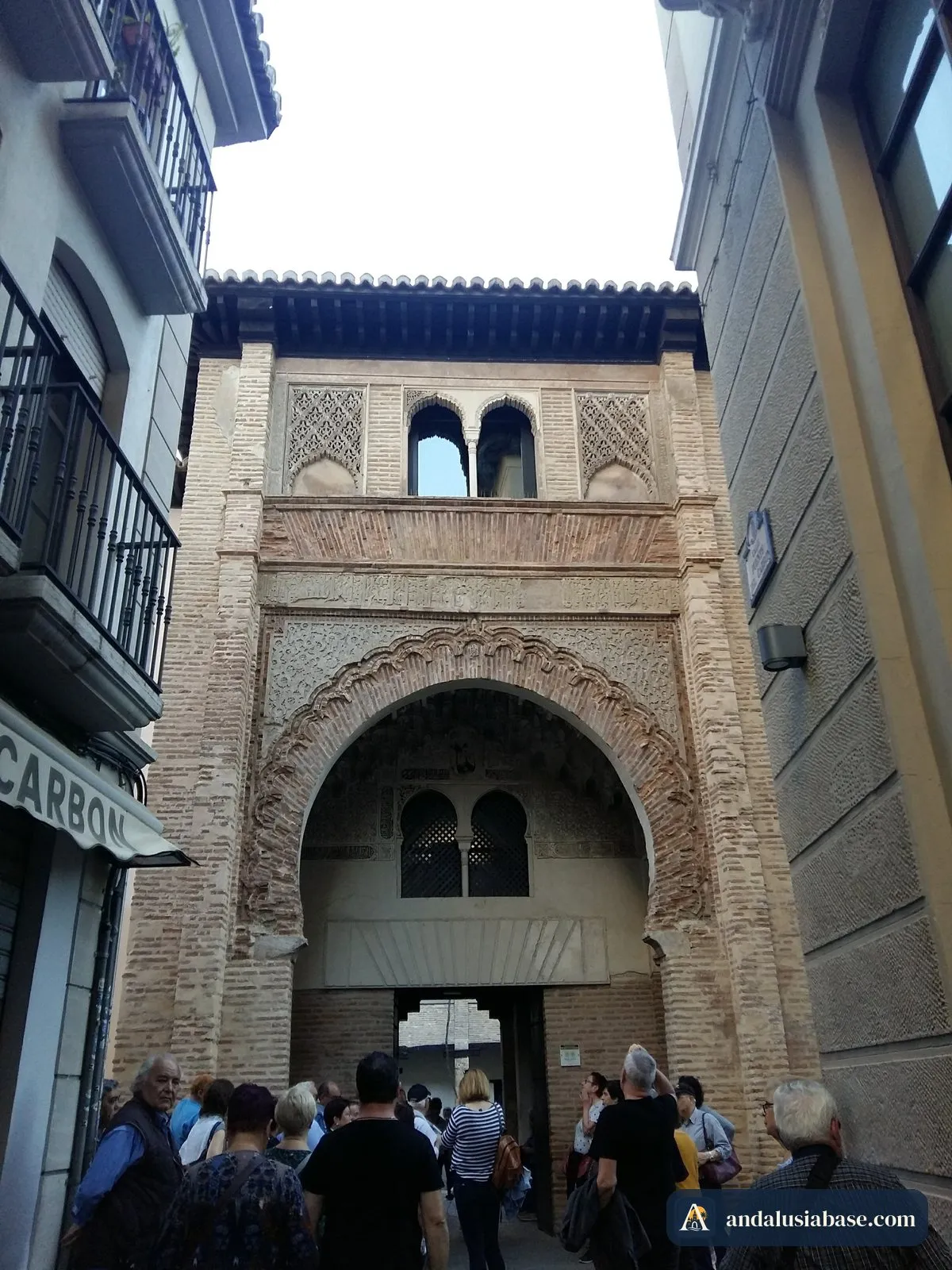 O portal nasrida em arco de ferradura, ricamente lavrado, do Corral del Carbón