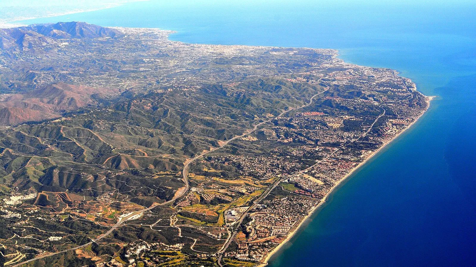 Vista aérea da Costa del Sol entre Marbella e Fuengirola, com as praias, as localidades e as montanhas ao fundo