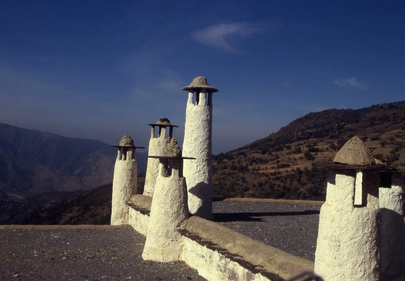 Chimeneas tradicionales encaladas sobre un terrado en Capileira, en la Alpujarra