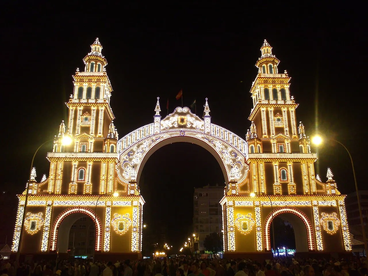 Das beleuchtete Eingangstor der Feria de Abril in Sevilla bei Nacht