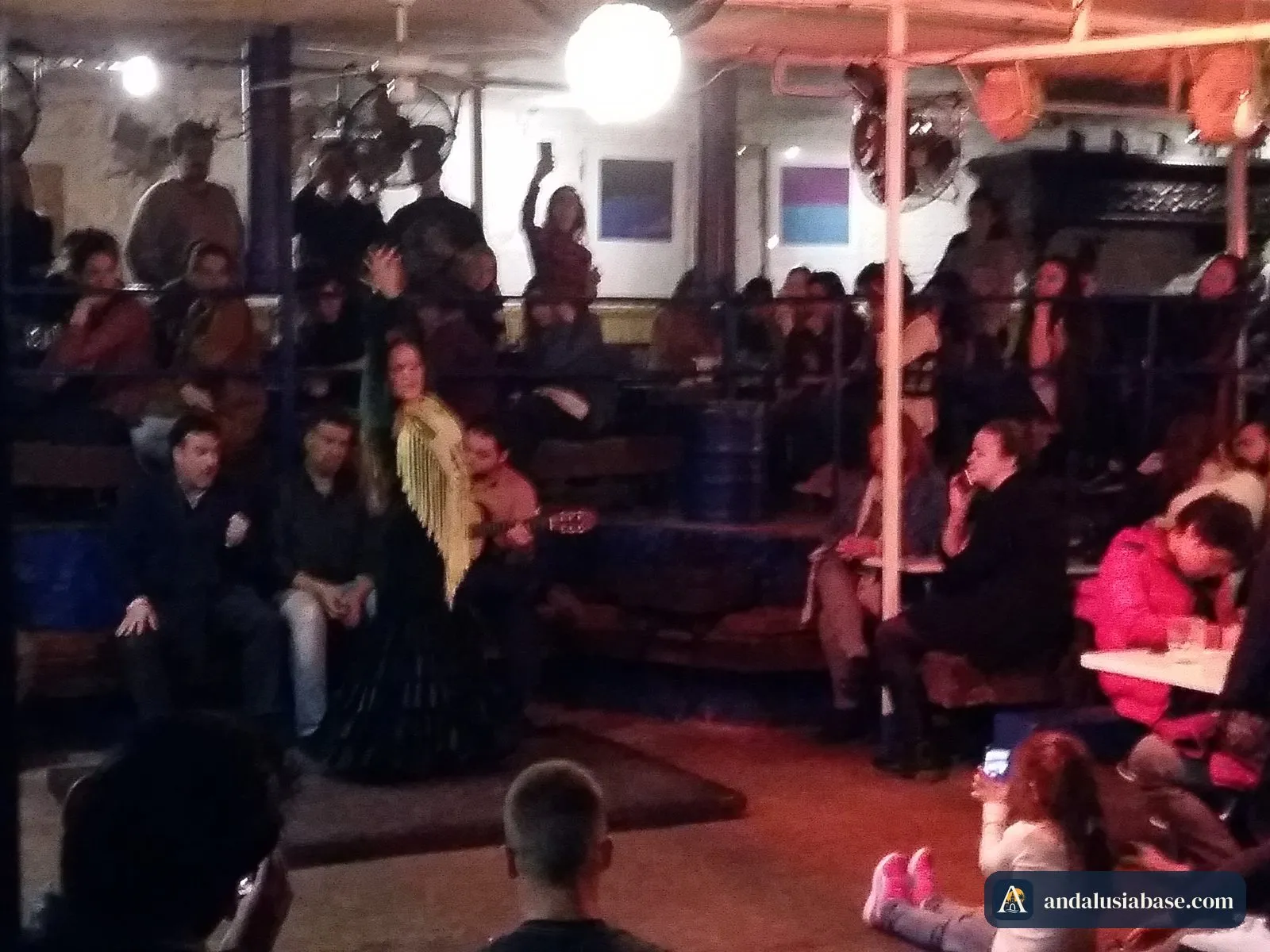 Bailarina de flamenco a dançar no meio do público sentado em Sevilha