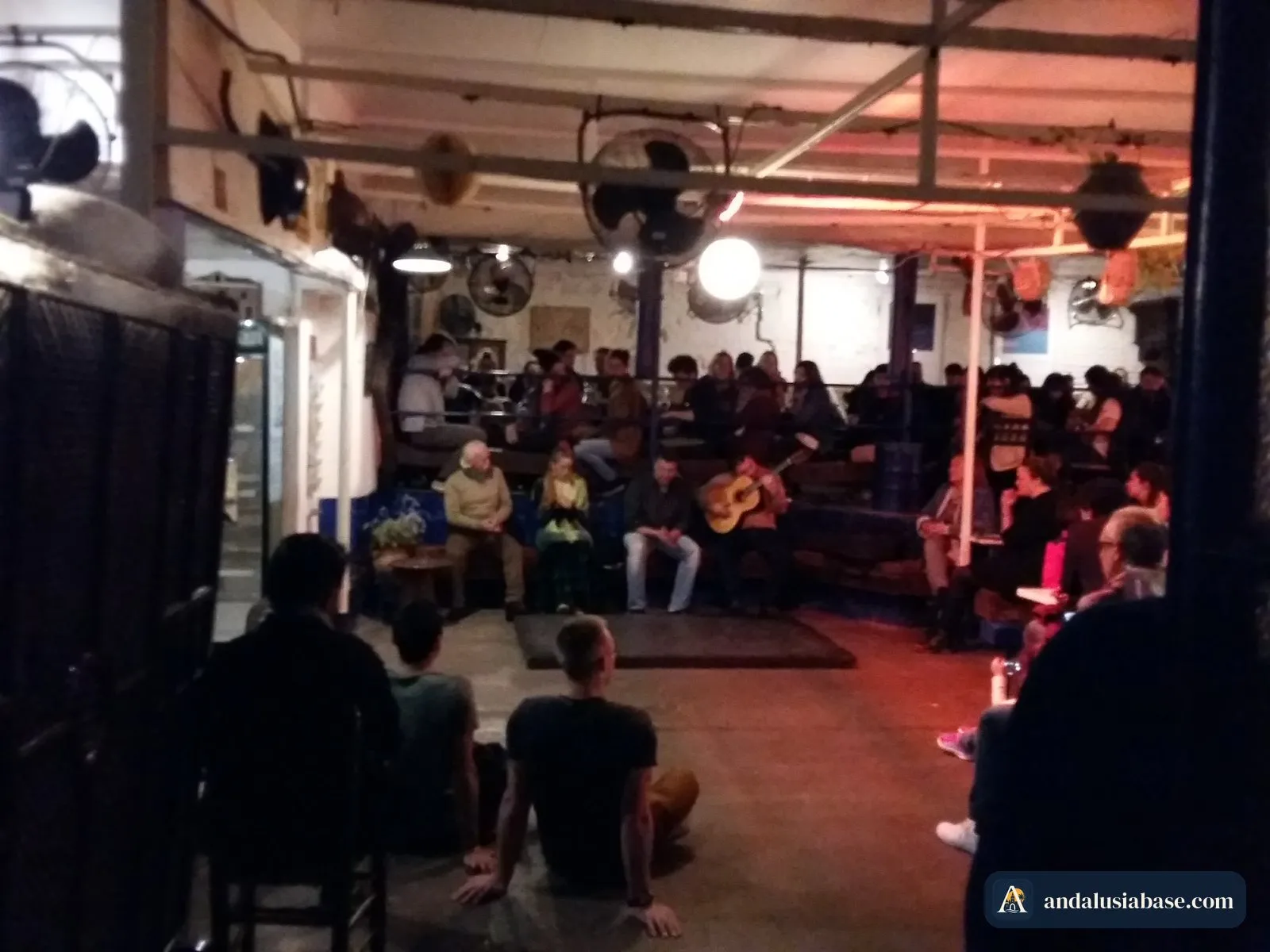 Público sentado a poucos metros do guitarrista e do cantor num pequeno espetáculo de flamenco em Sevilha