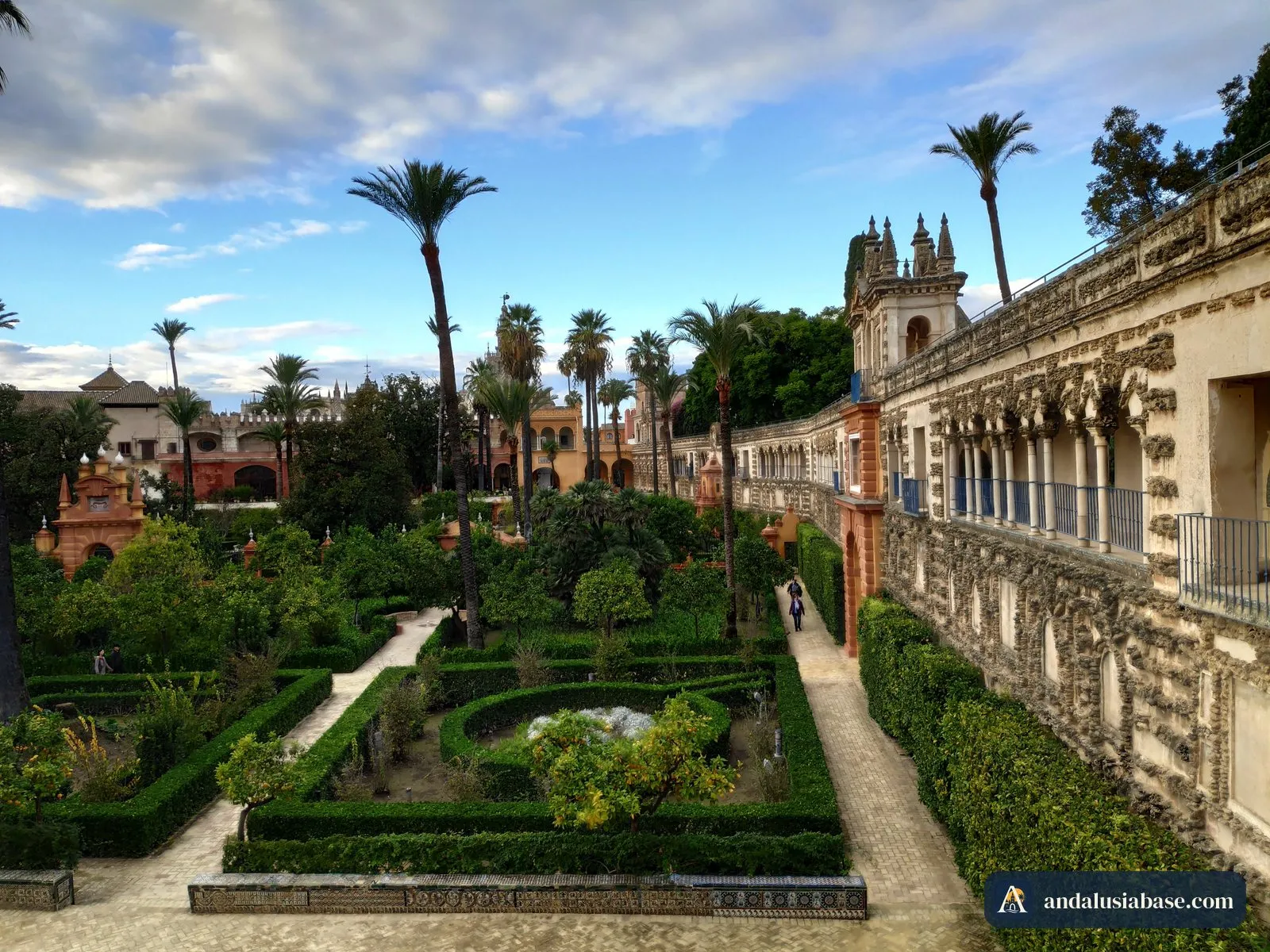 Canteiros de sebes, laranjeiras e palmeiras sob a Galería del Grutesco nos jardins do Alcázar