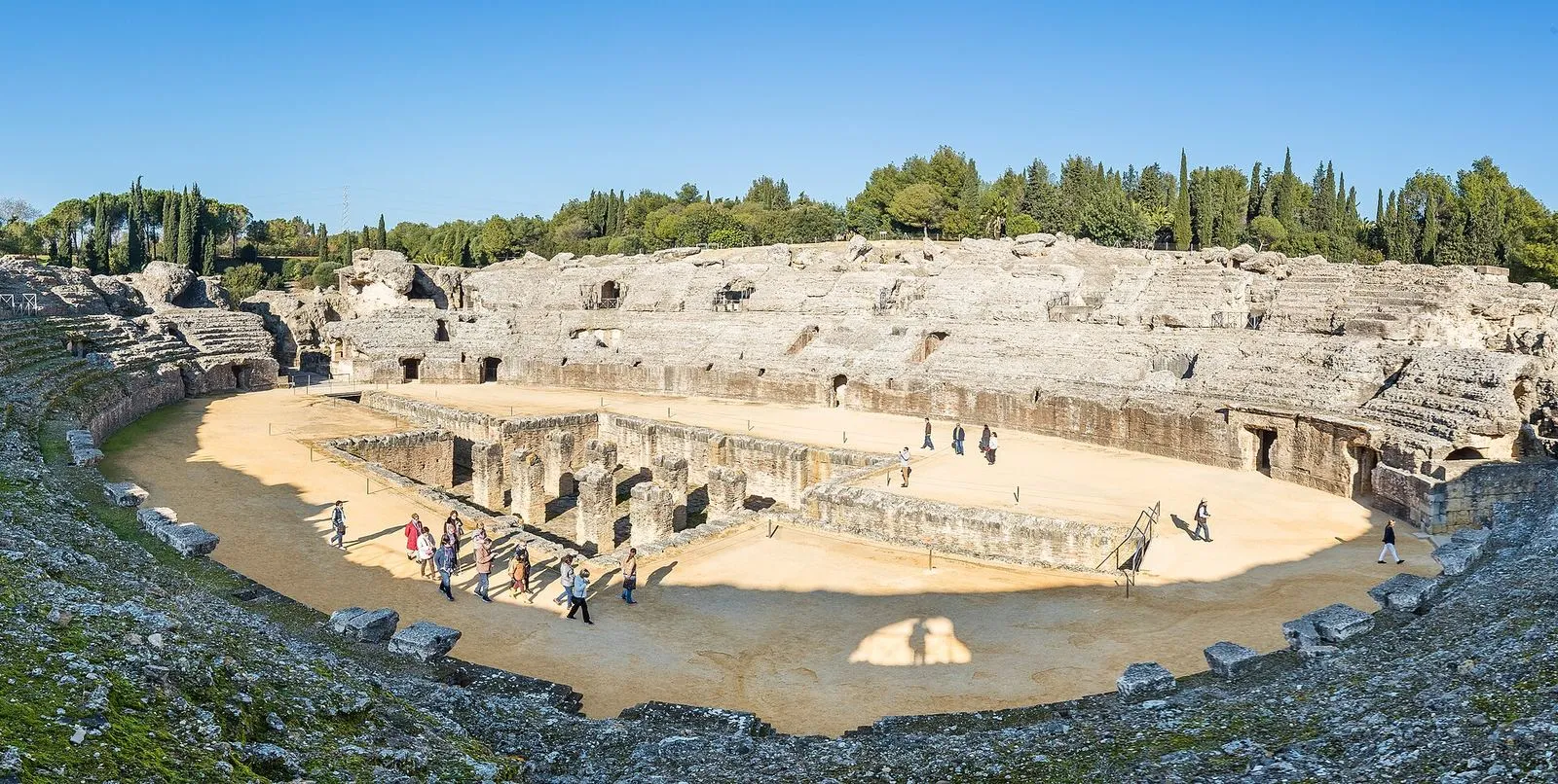 Panorâmica do anfiteatro romano de Itálica, perto de Sevilha, com a arena, as bancadas de pedra e ciprestes