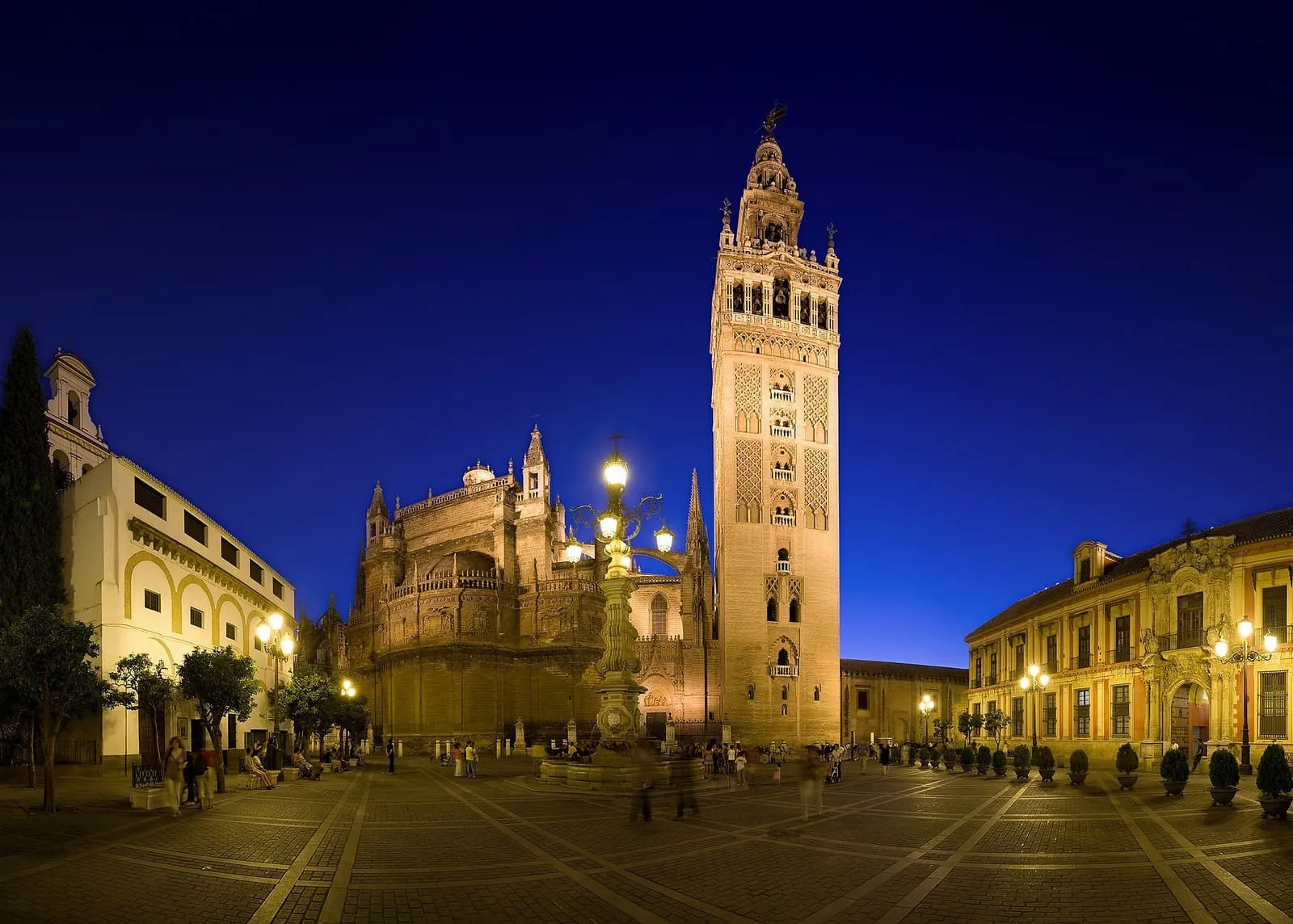 La Plaza Virgen de los Reyes de noche, con la Giralda y la Catedral de Sevilla iluminadas
