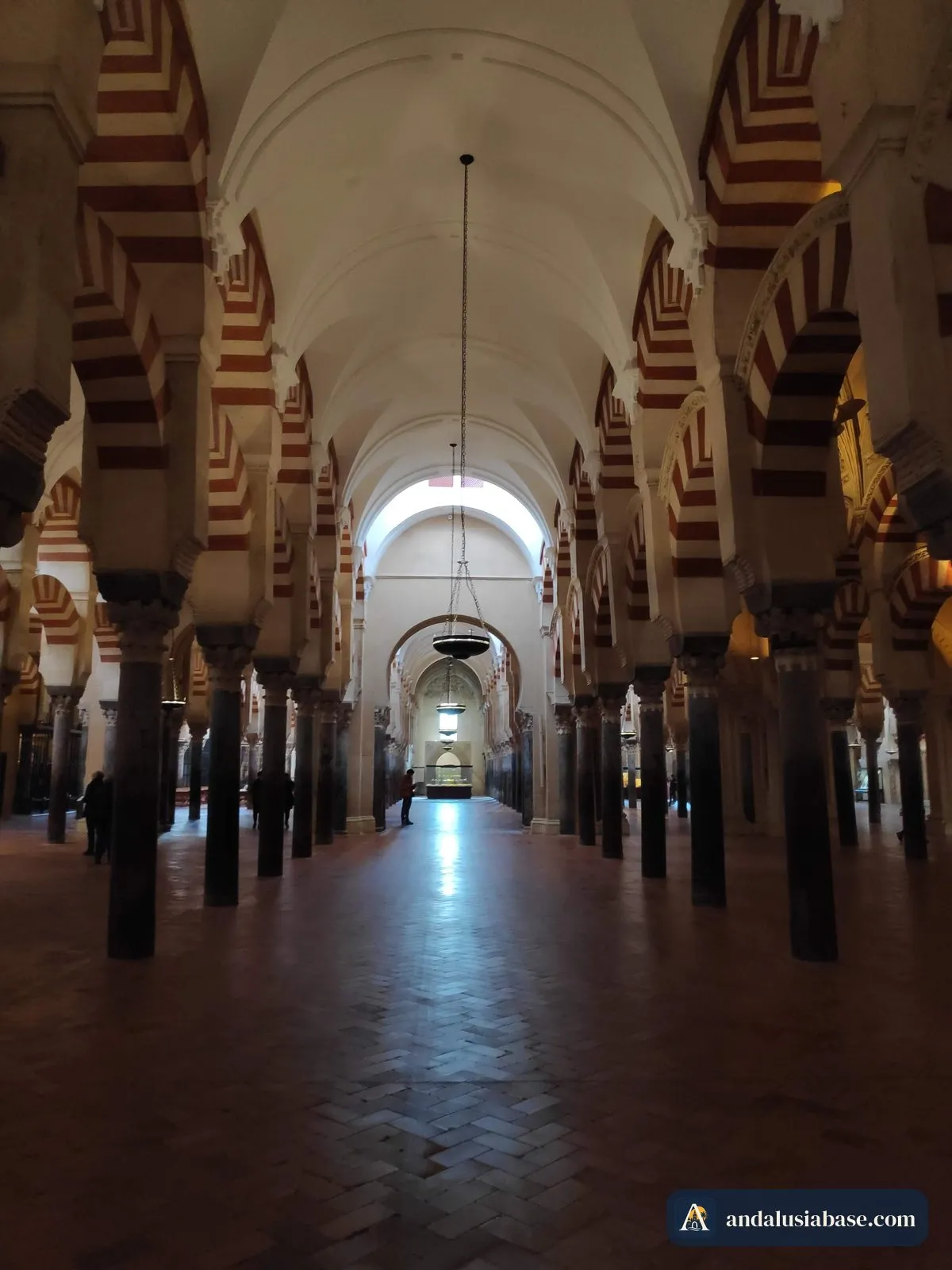 Um longo corredor tranquilo de colunas e arcos na Mesquita