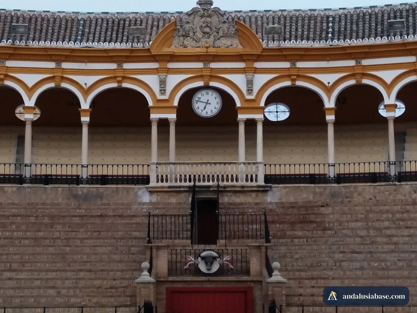 No interior da praça de touros da Maestranza, no Arenal: a areia, o relógio e o camarote real com arcos