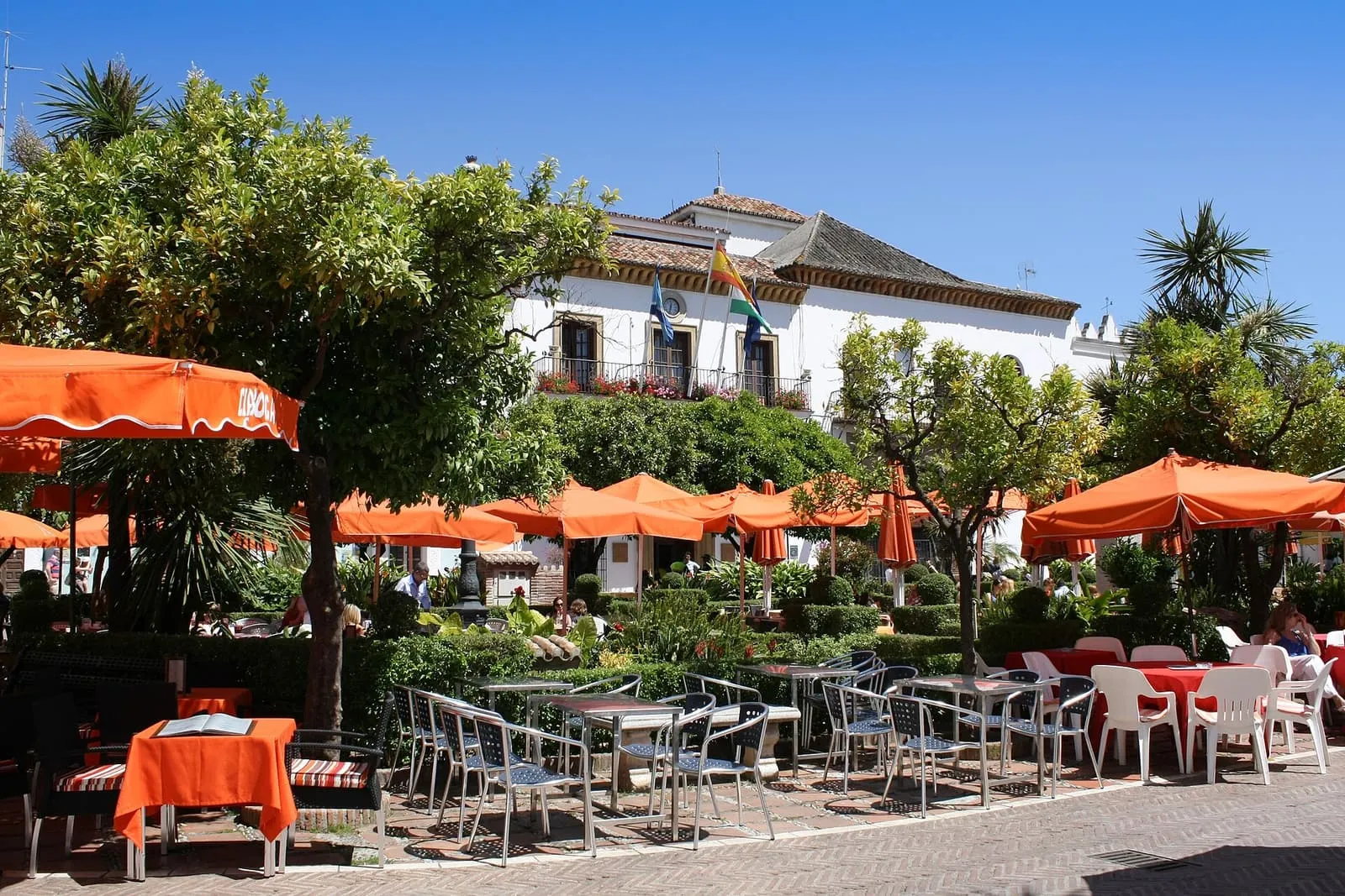 Terrazas con sombrillas naranjas en la Plaza de los Naranjos de Marbella, frente al Ayuntamiento