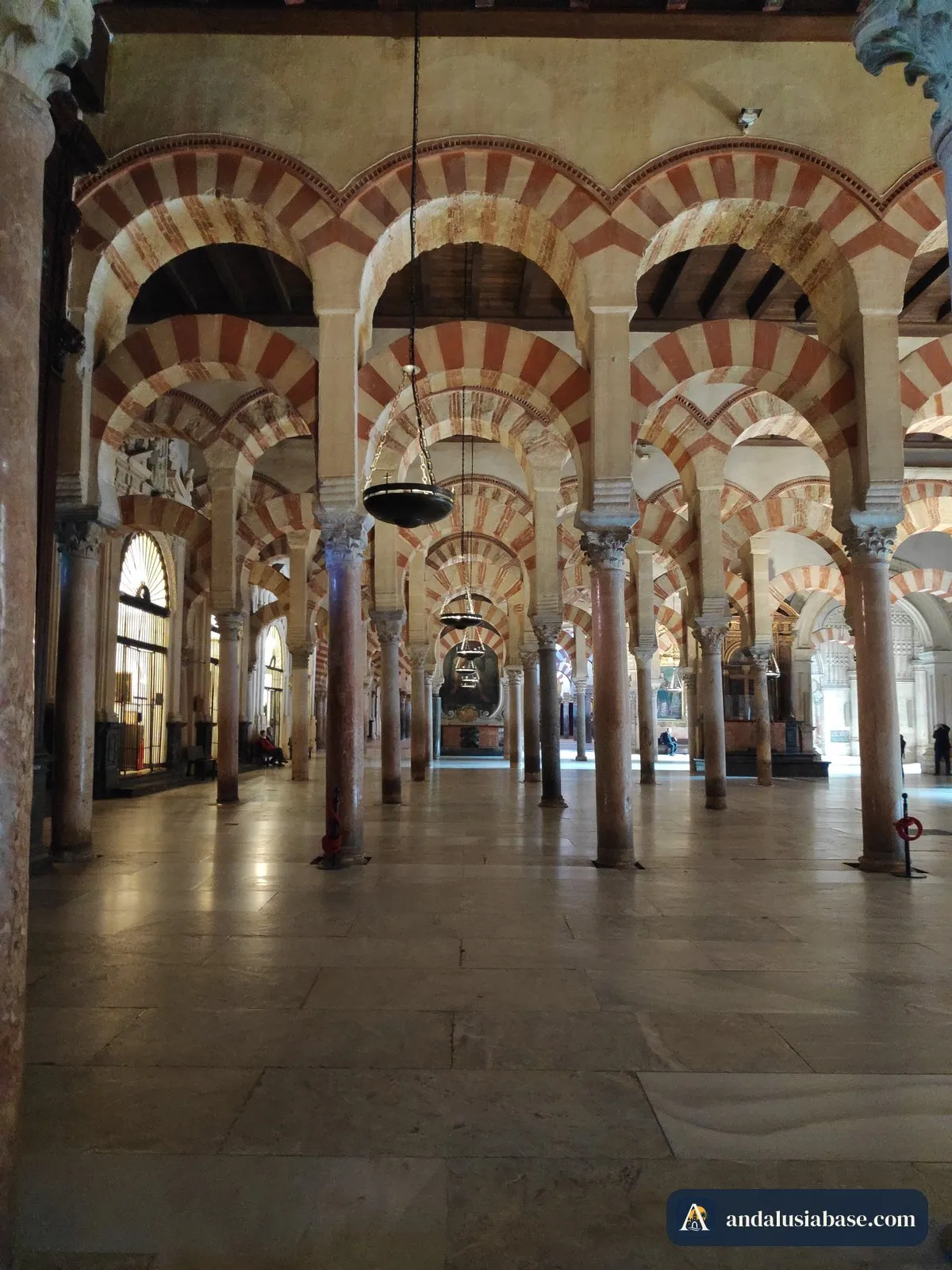 Filas de arcos vermelhos e brancos no interior da Mesquita de Córdova