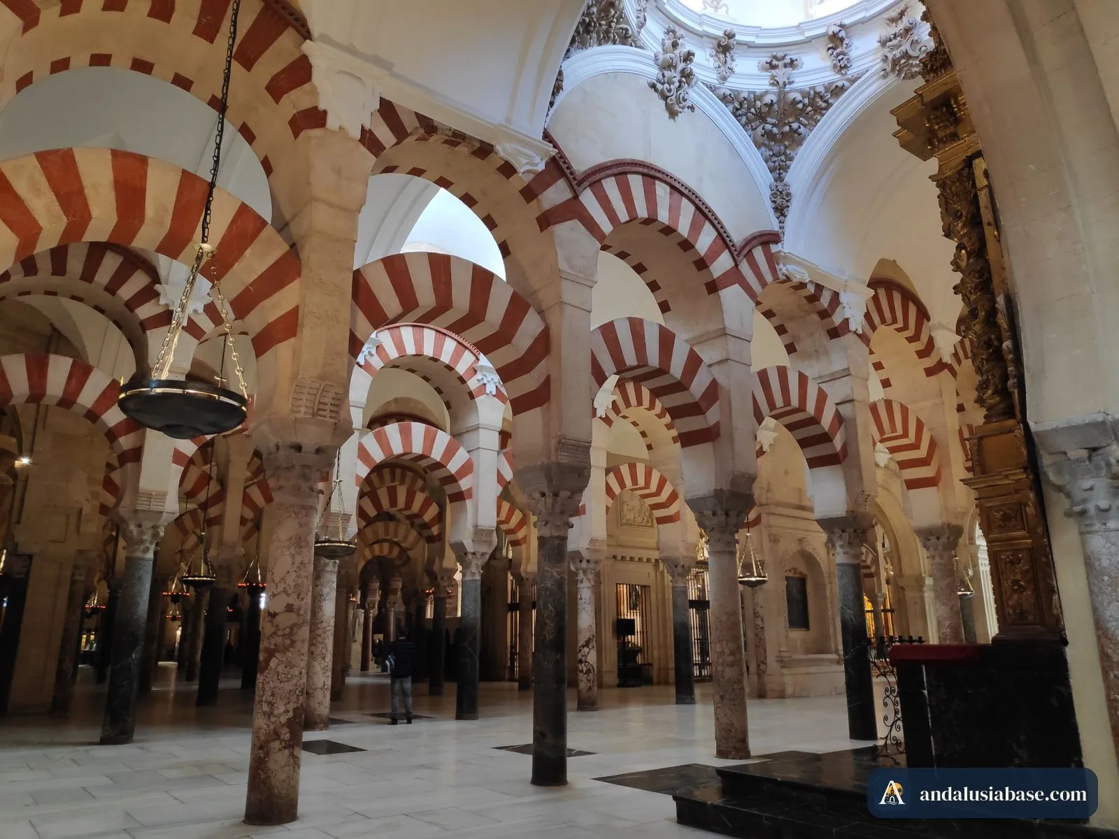 Hanging lamps among the striped arches of the Mezquita-Catedral of Córdoba