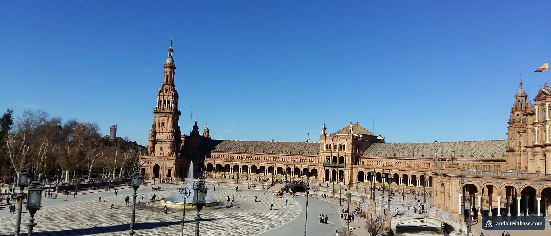 A Plaza de España em Sevilha sob um céu limpo de janeiro, com a torre, a fonte e o edifício em semicírculo