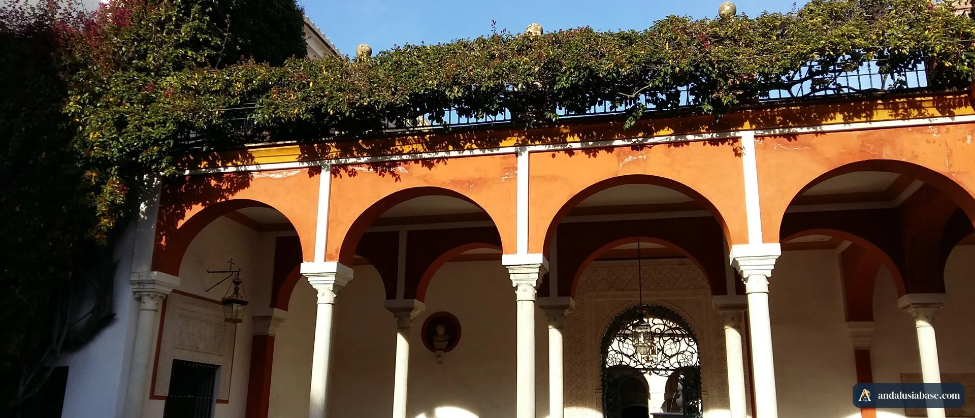 Sol de inverno nas arcadas ocre e nas buganvílias do jardim da Casa de Pilatos, em Sevilha, em fevereiro