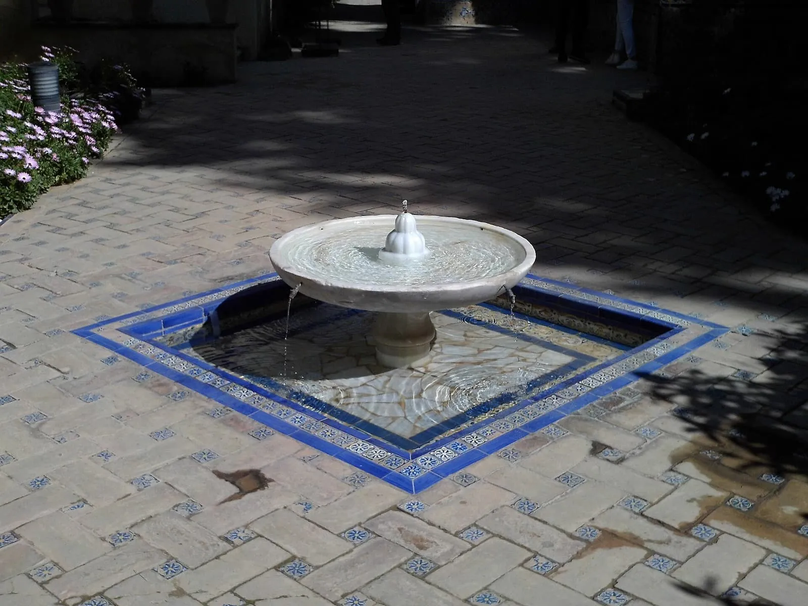 Una fuente de mármol en un pilón de azulejos en los jardines del Real Alcázar, Sevilla