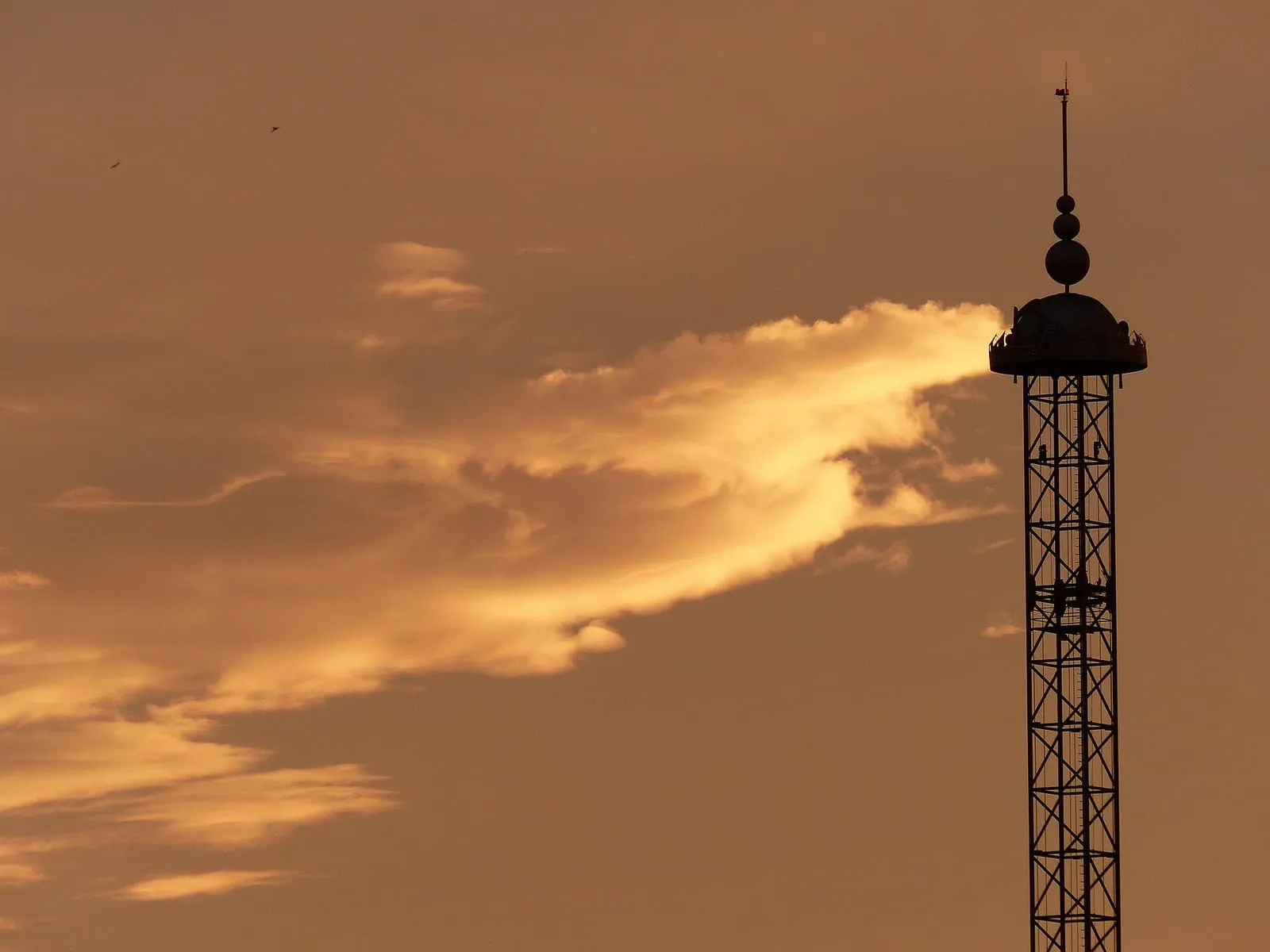 Die Silhouette des Freifallturms El Desafío in der Isla Mágica vor goldenem Abendhimmel, Sevilla