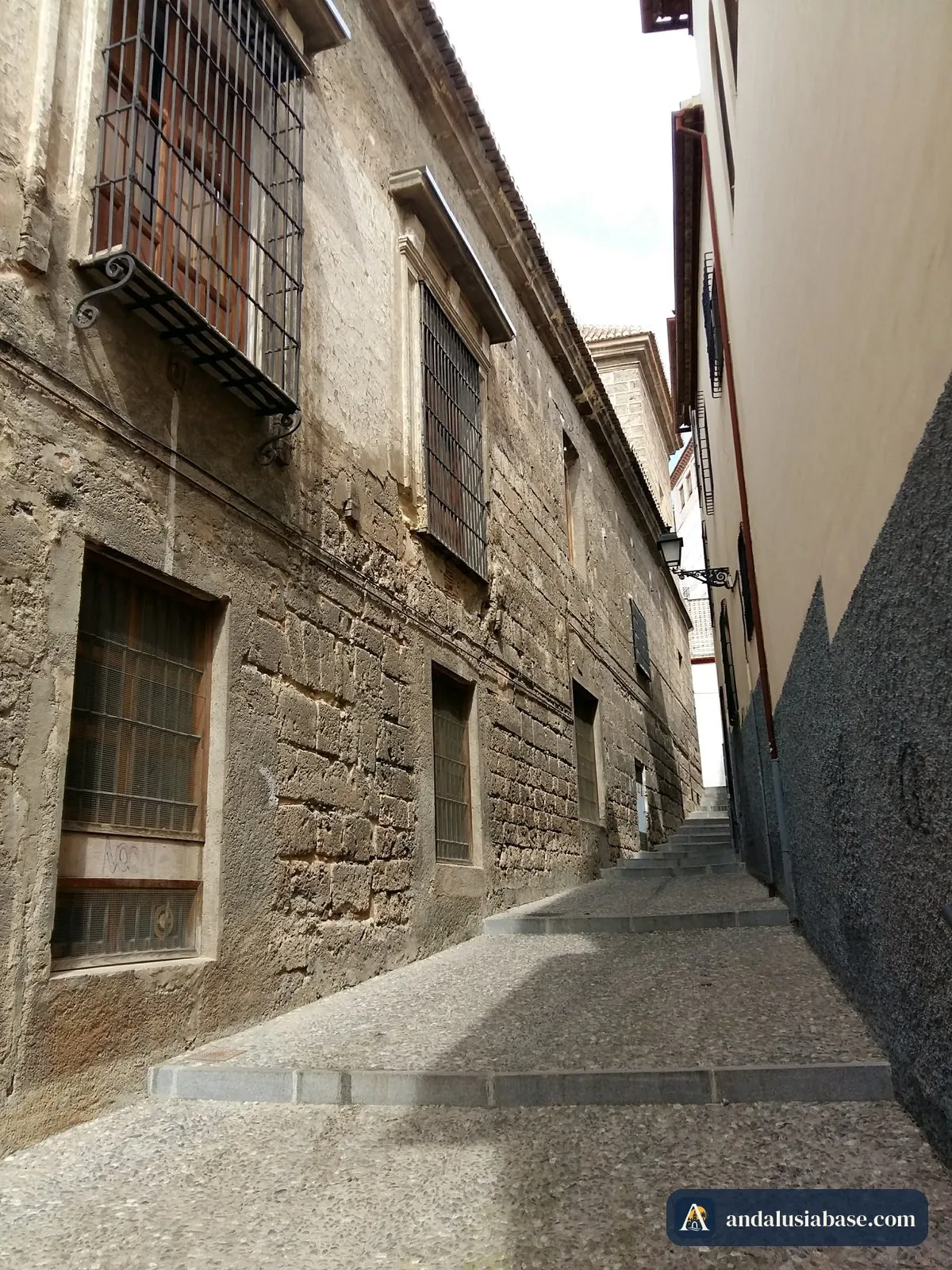 Uma ruela estreita e empedrada entre velhas casas de pedra no Albaicín