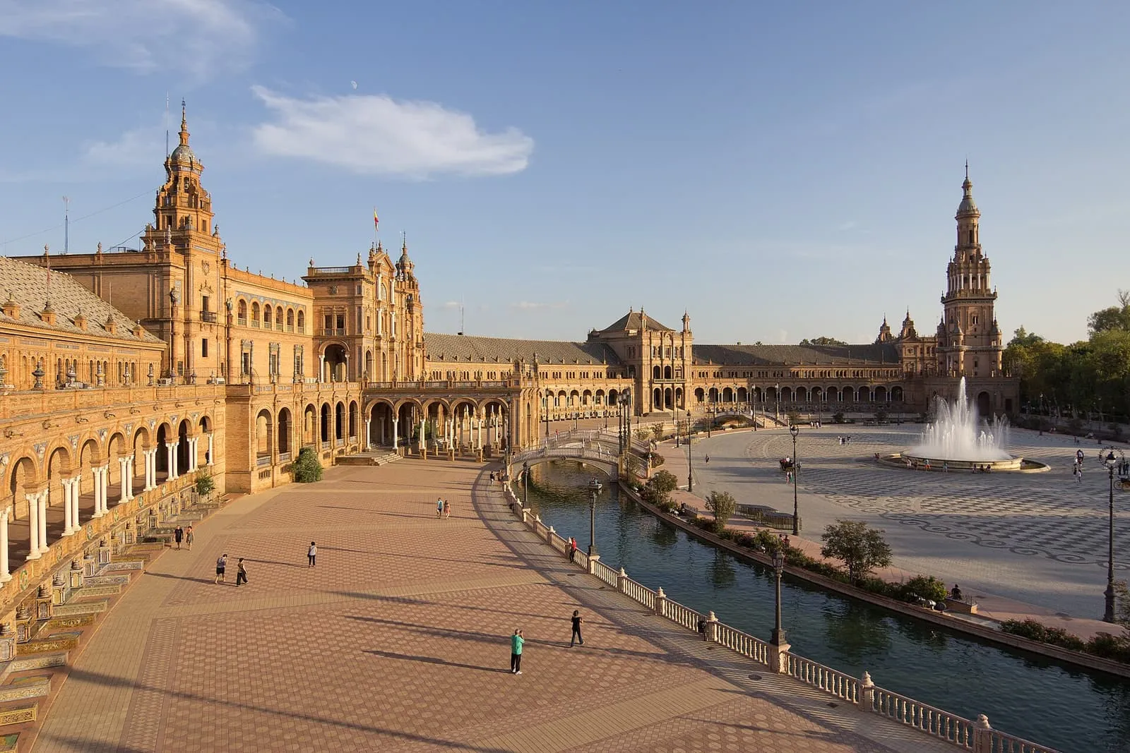 Die Plaza de España in Sevilla mit halbrundem Backsteinpalast, Kanal und Springbrunnen