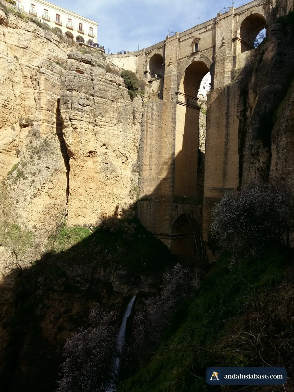 A Puente Nuevo vista do fundo do desfiladeiro, com uma cascata sob o arco