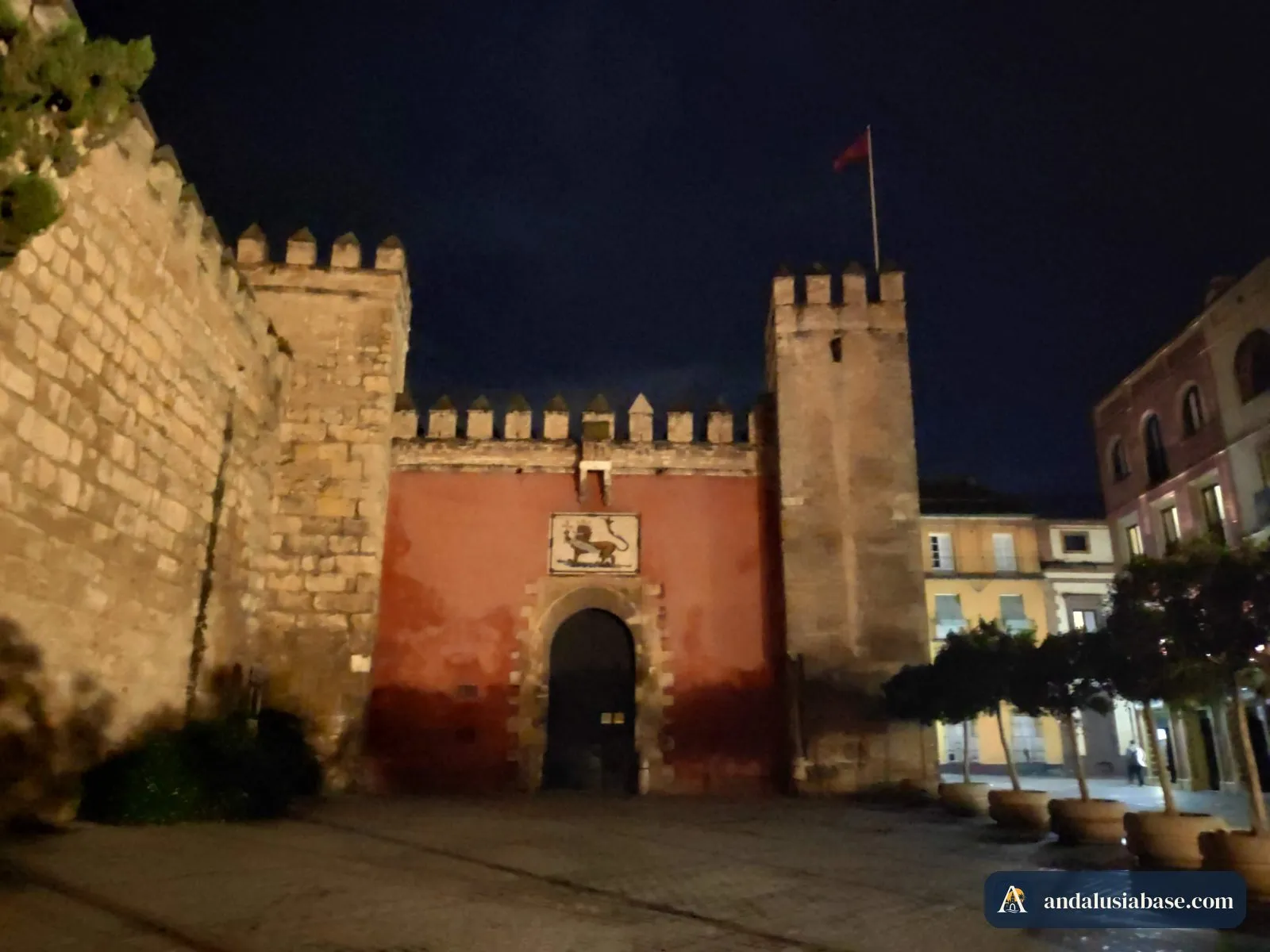 A Puerta del León e as muralhas do Alcázar iluminadas à noite na Plaza del Triunfo