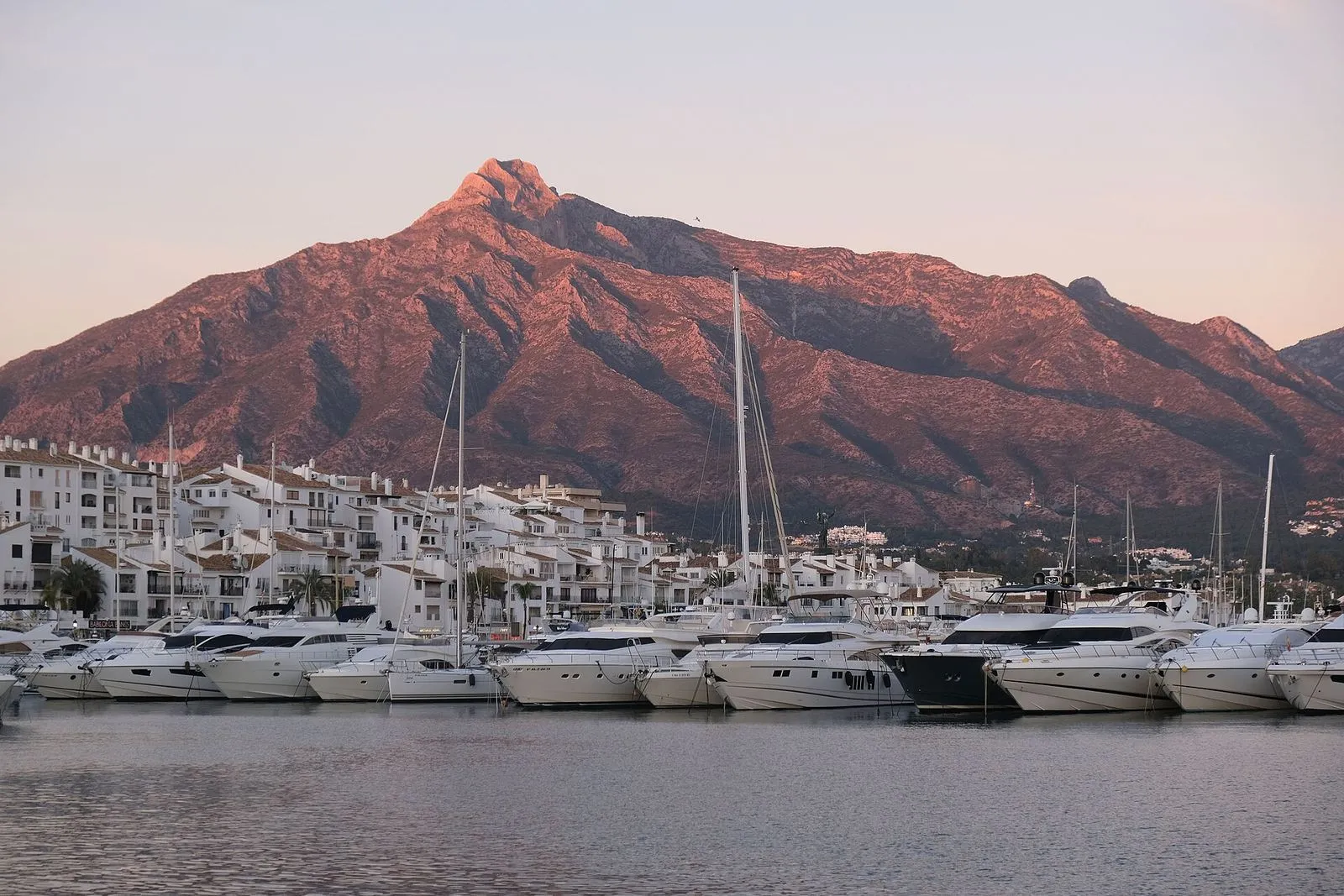 Jachten im Hafen von Puerto Banús, dahinter der Berg La Concha im rosa Licht des Sonnenuntergangs