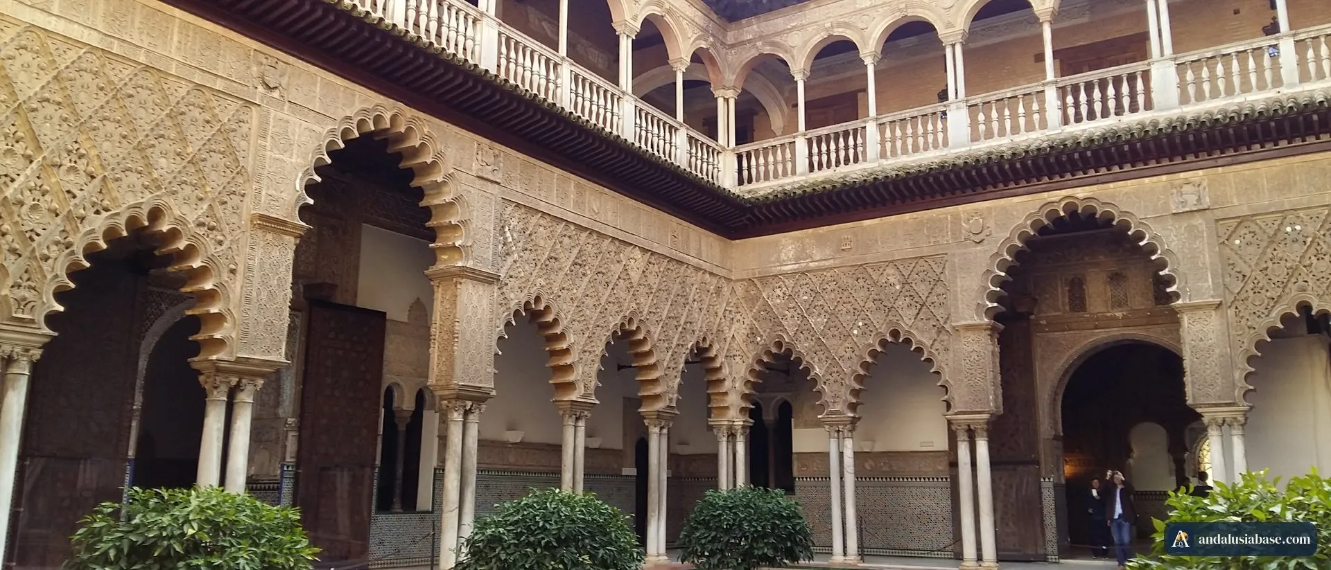 O Pátio de las Doncellas no Real Alcázar de Sevilha, com os arcos mudéjares recortados e a galeria superior