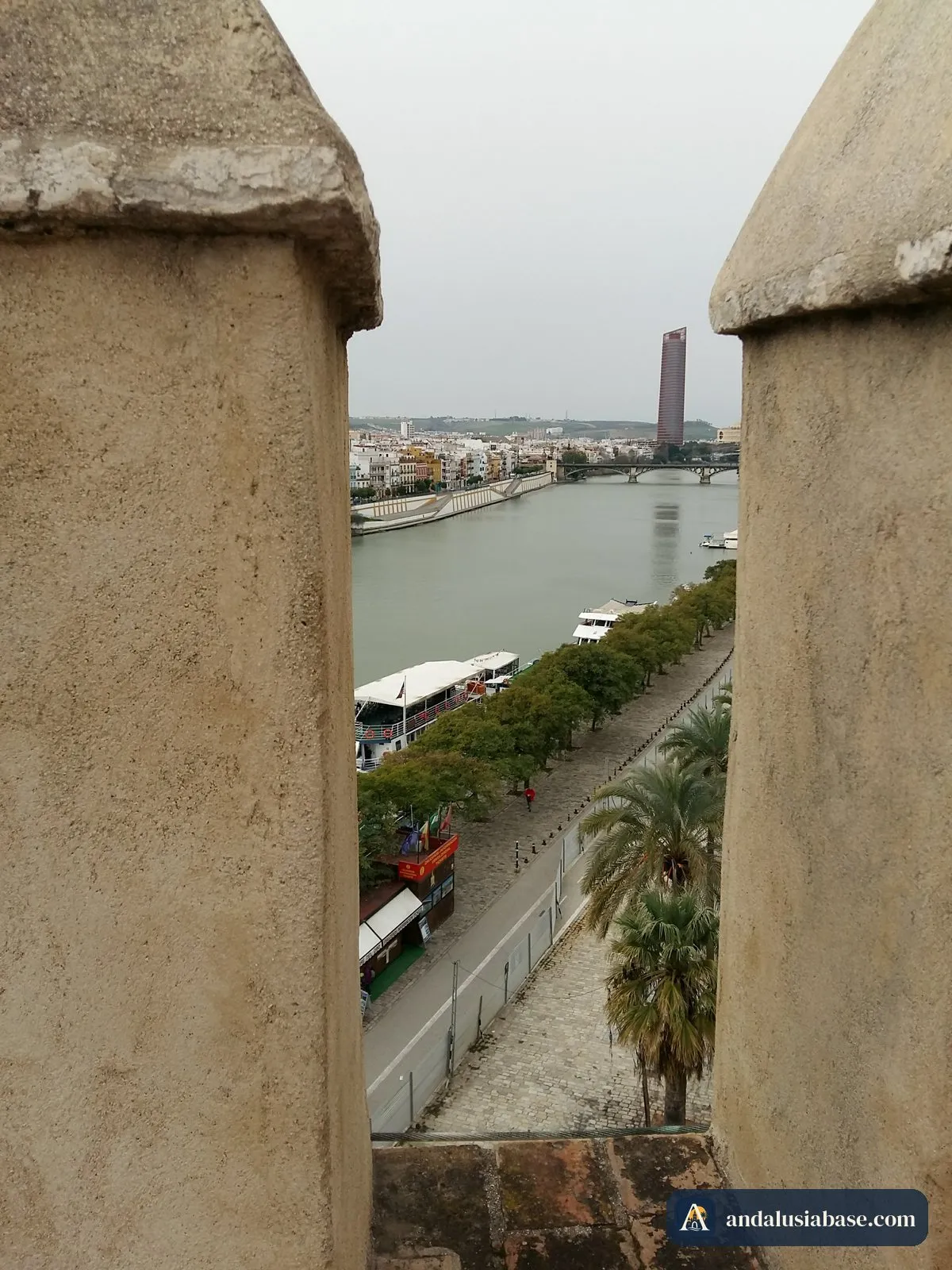 O Guadalquivir e o passeio ribeirinho enquadrados pelas ameias da Torre del Oro num dia de fevereiro