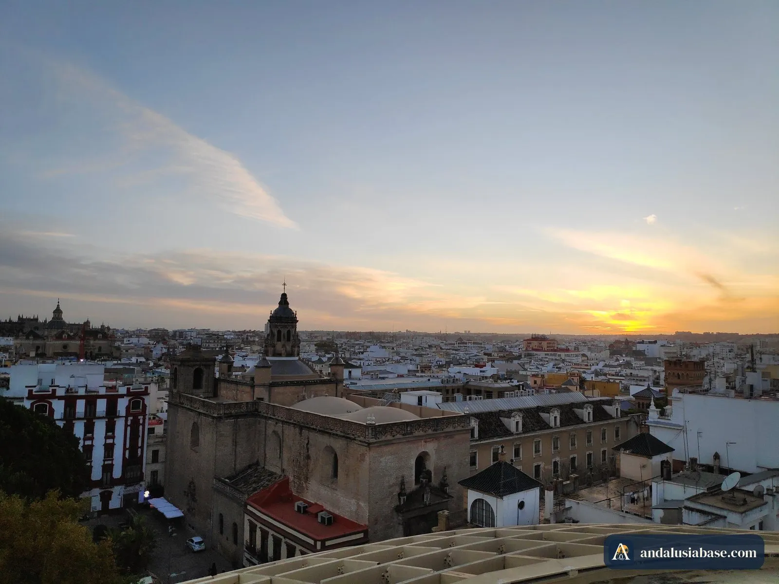 A cúpula de uma igreja e os telhados do centro histórico na luz quente do pôr do sol, vistos do topo das Setas