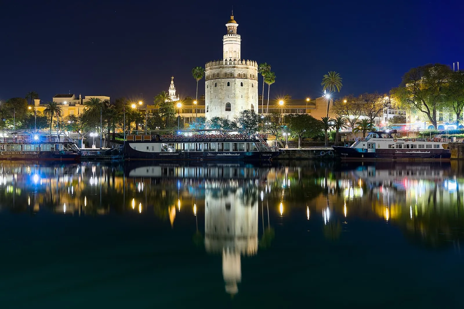 La Torre del Oro illuminata di notte e riflessa nel Guadalquivir, a Siviglia