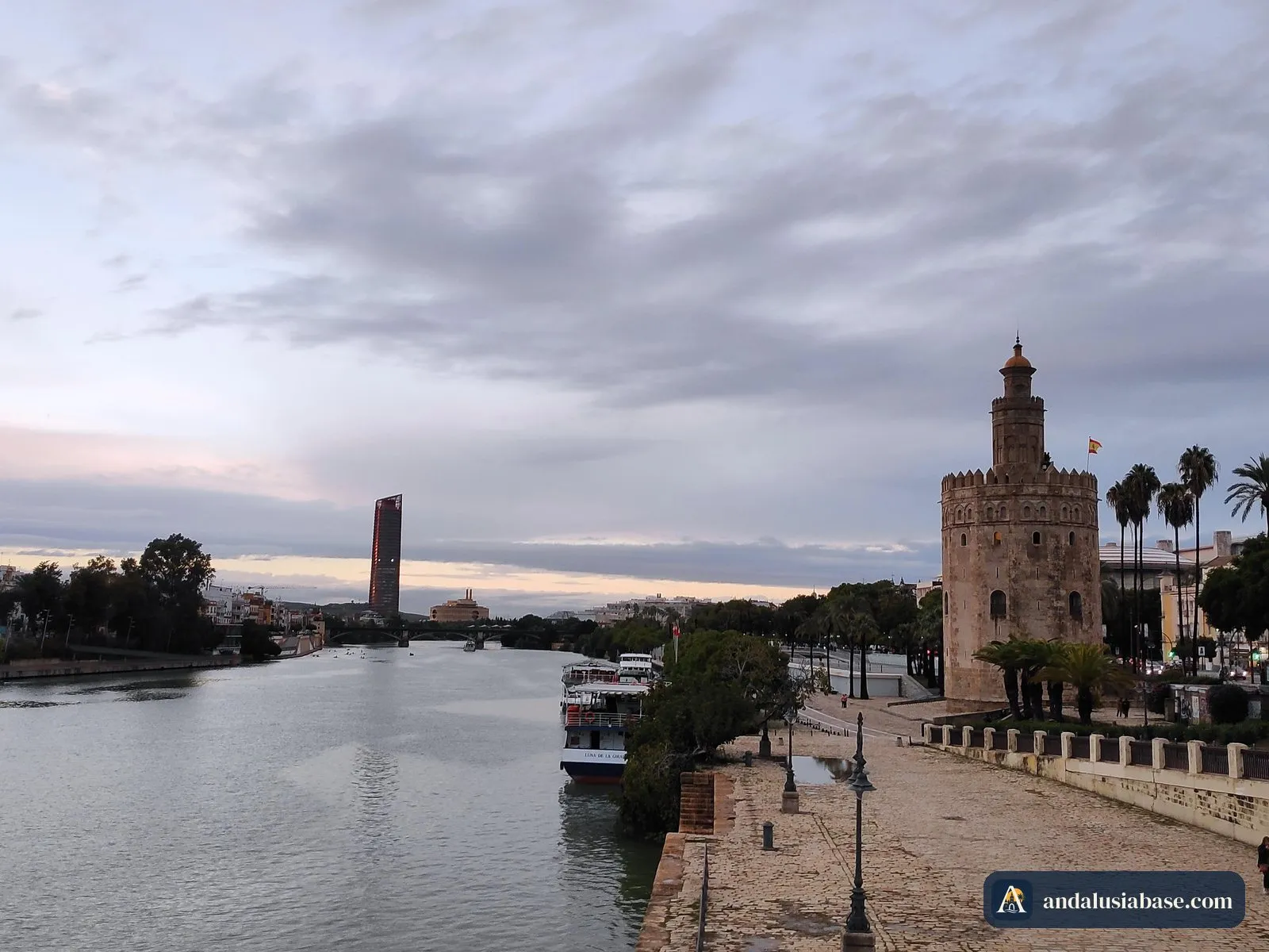 A Torre del Oro junto ao passeio do rio ao entardecer