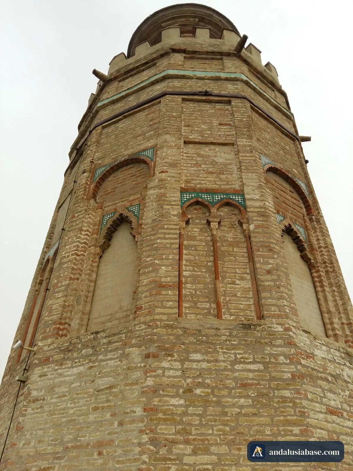 Vista de baixo das paredes de tijolo e dos corpos superiores da Torre del Oro dodecagonal