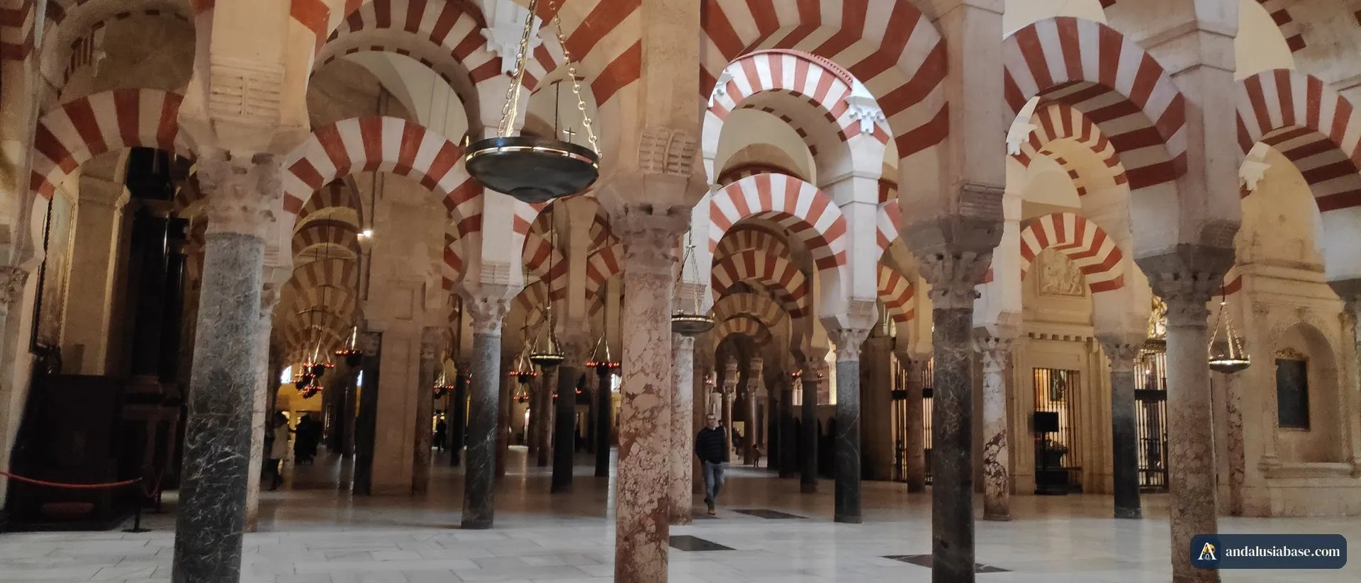 Colunas e arcos vermelhos e brancos a perder de vista no interior da Mesquita de Córdoba