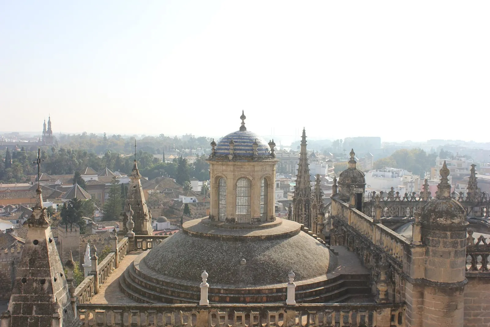 Cúpulas y pináculos de la Catedral de Sevilla sobre los tejados en un día de otoño brumoso