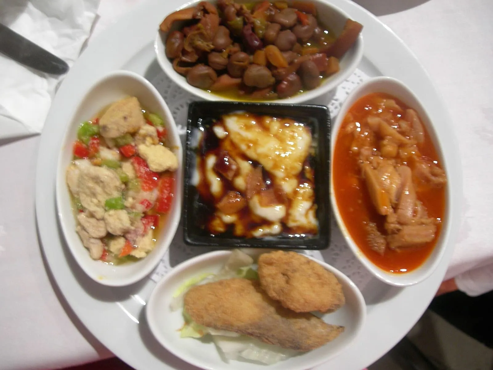 Ein Probierteller mit fünf Tapas in kleinen Schälchen in einem Restaurant in Sevilla